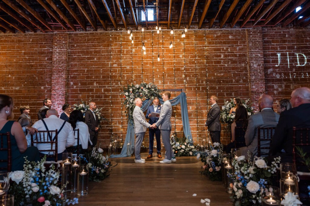 Elegant Dusty Blue Ceremony Decor with Draped Arch | NOVA 535 Industrial St Pete Wedding Venue with Brick Walls