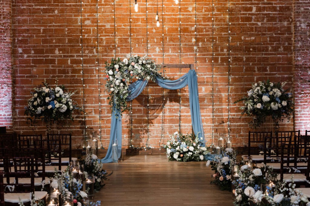 Elegant Dusty Blue Ceremony Decor with Draped Arch | NOVA 535 Industrial St Pete Wedding Venue with Brick Walls